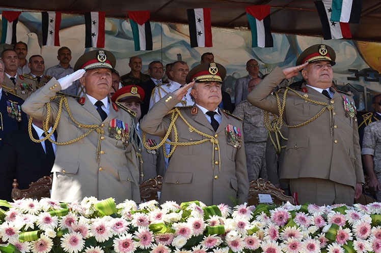 Milirares sirios saludan la bandera